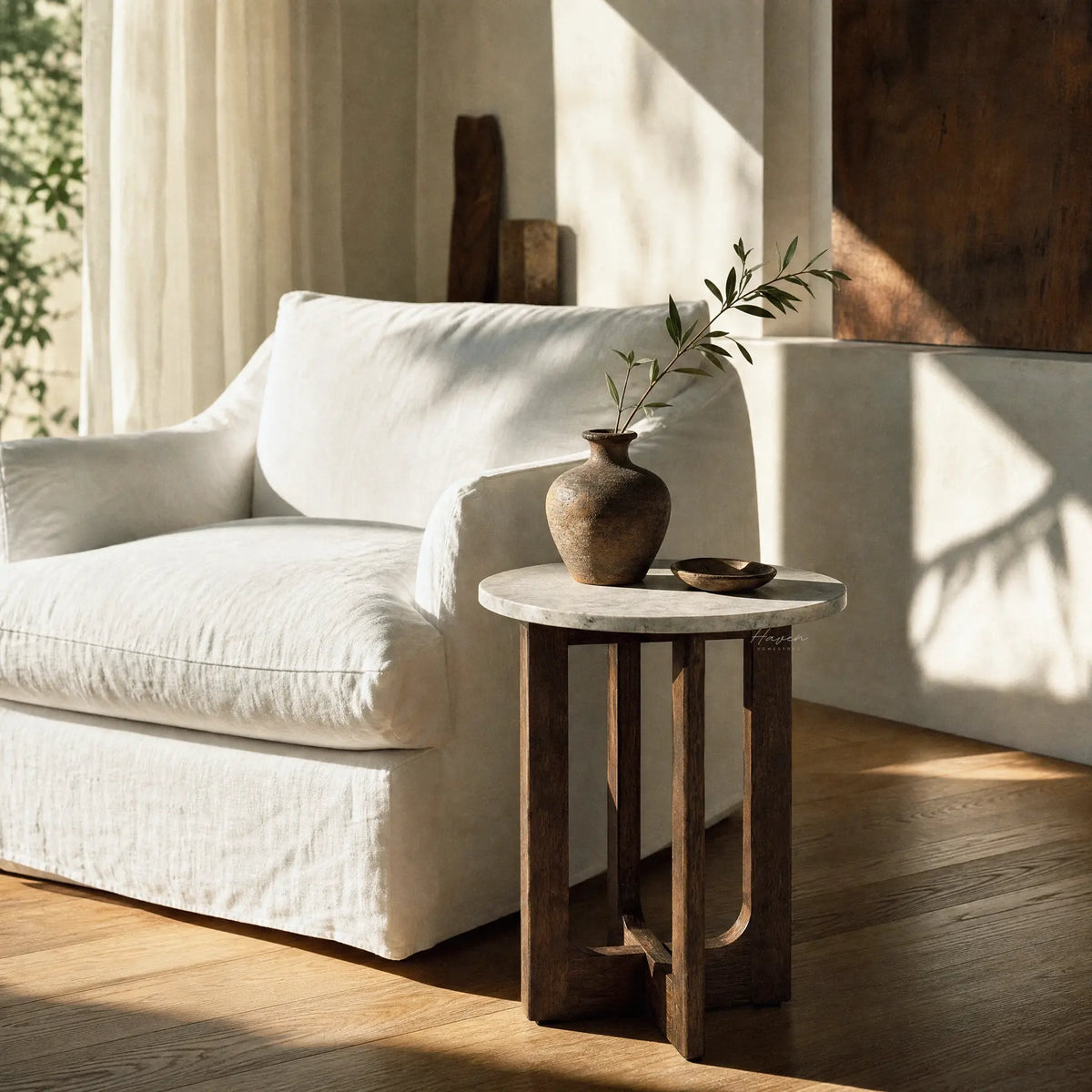 Soren Marble Side Table with round marble top and walnut-stained rubberwood base beside a white sofa.