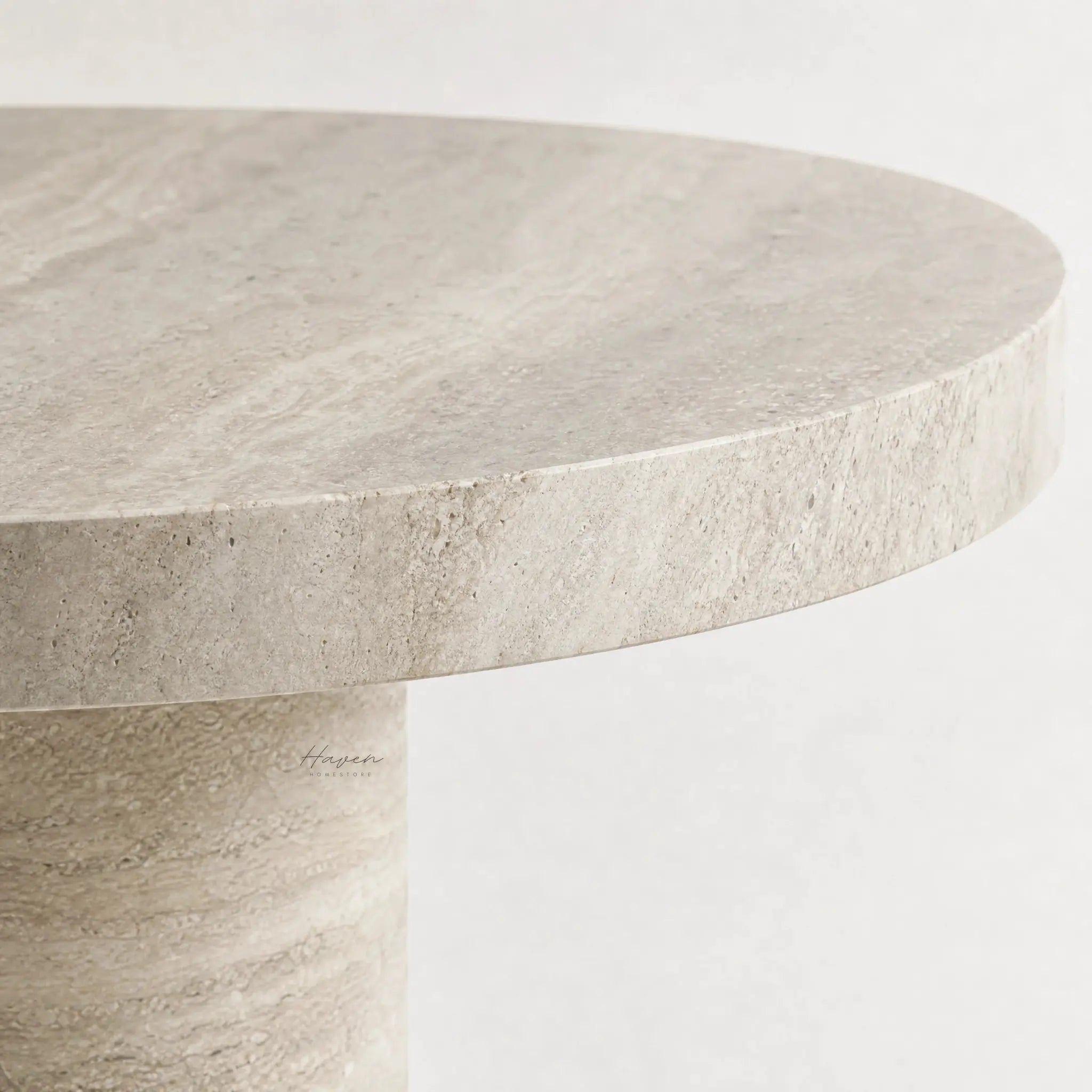 Round travertine dining table top with sculptural pedestal base.