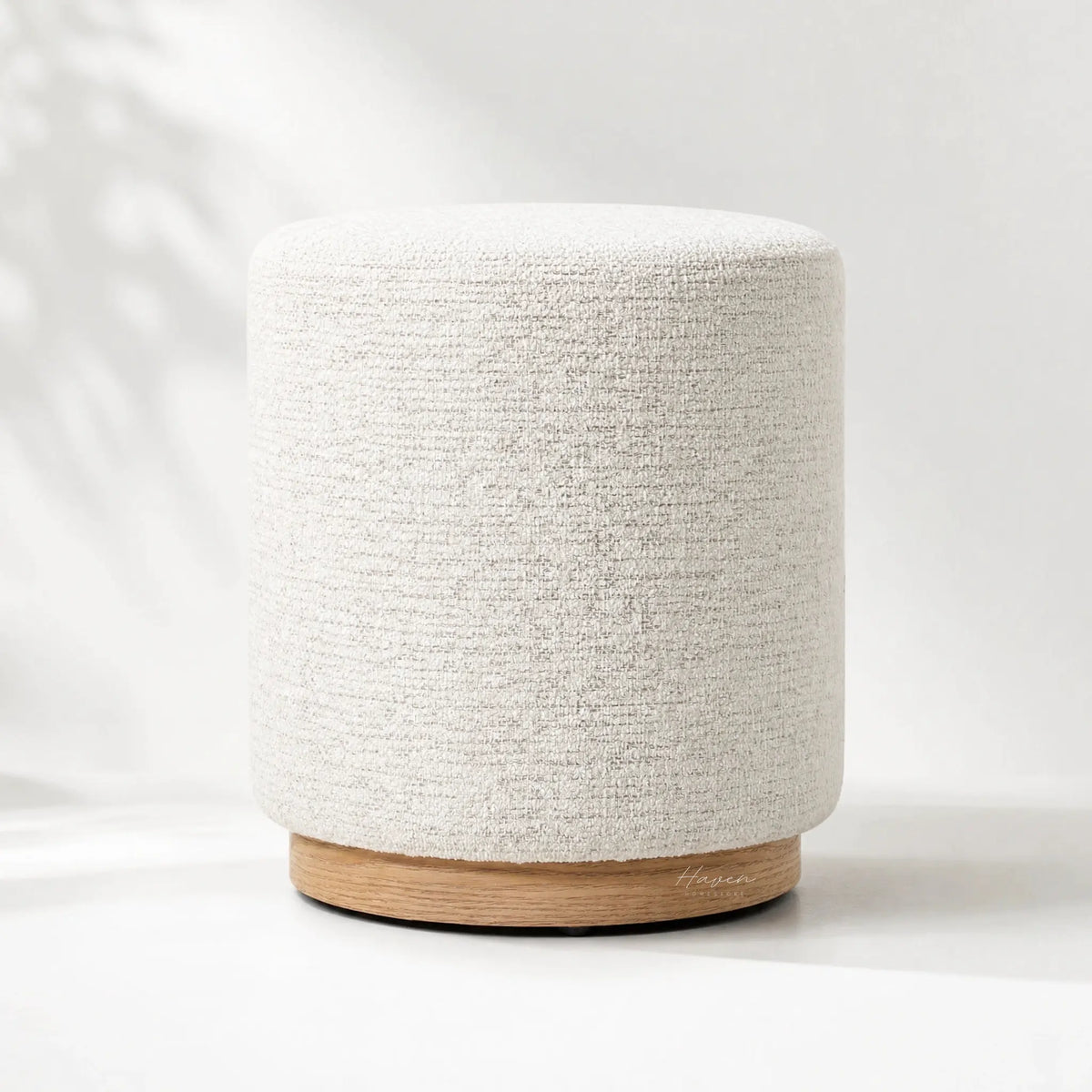 Palmetto Footstool with soft rounded form, textured polyester upholstery, and wooden base