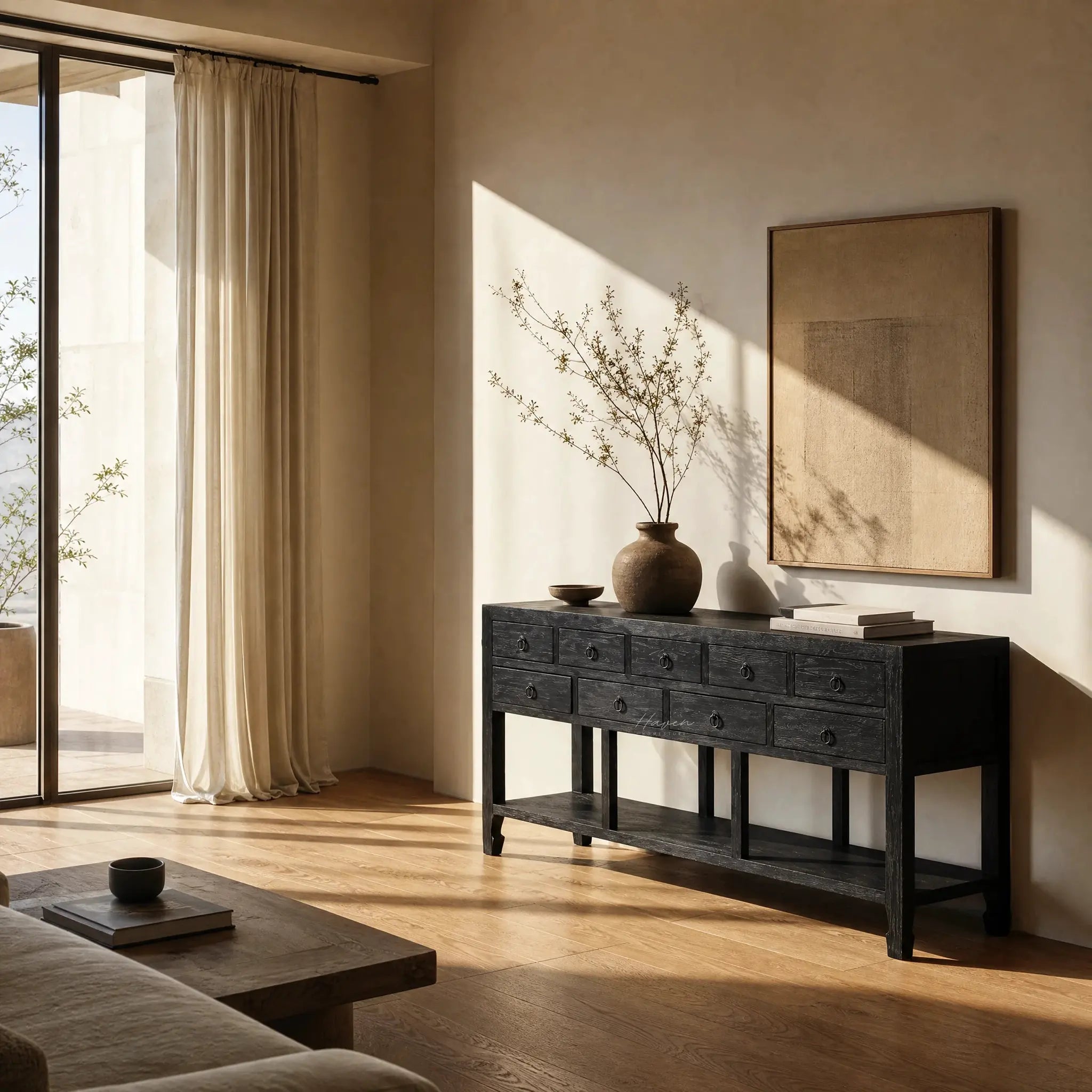 Blackwood Sideboard in sandblasted ebony oak with rich textured grain, shown with vase and books in a warm sunlit room.