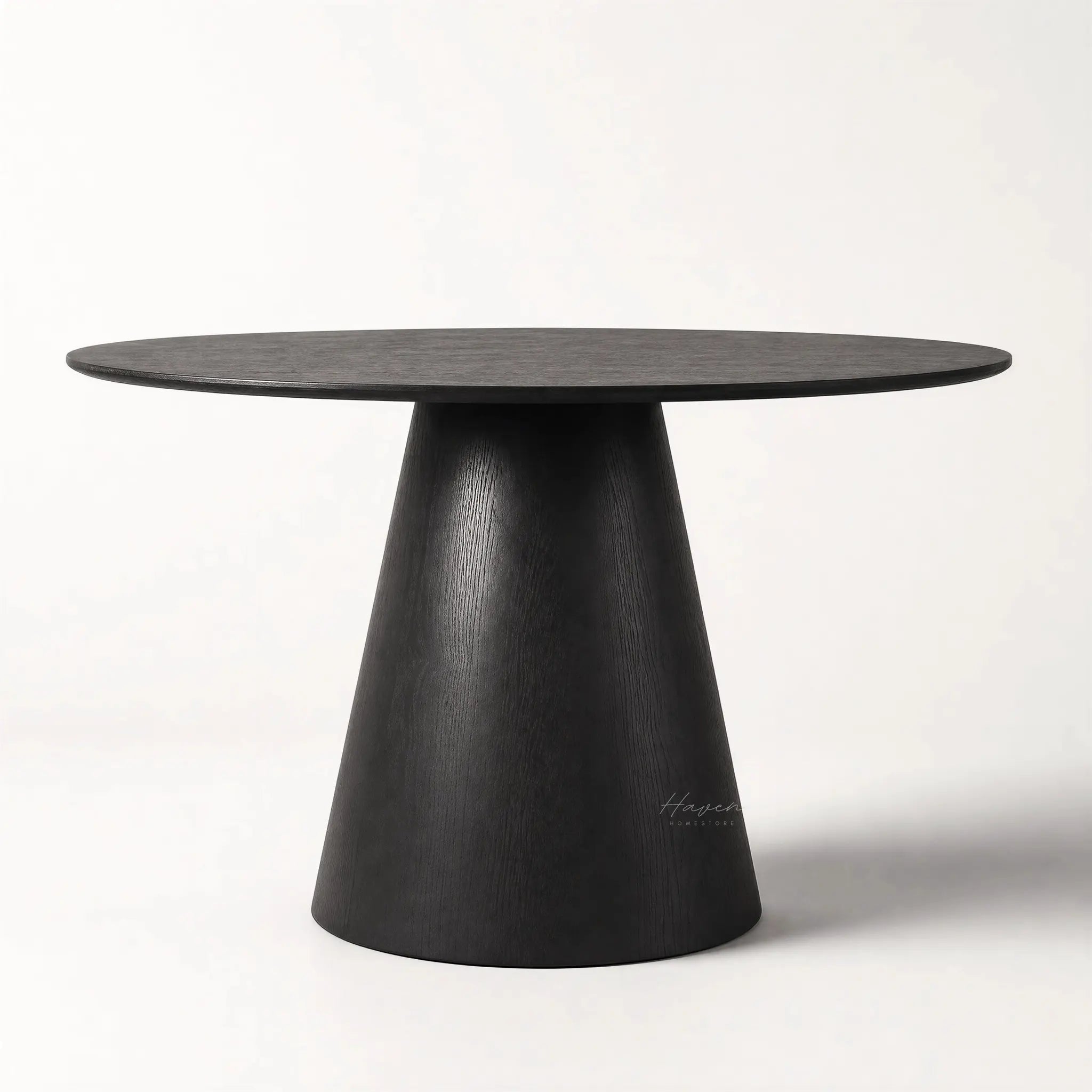 Charlie Dining Table with a rounded top and sculptural pedestal base in black oak veneer.
