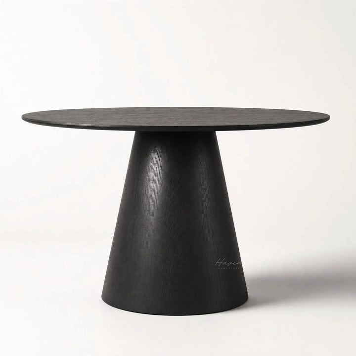 Charlie Dining Table with a rounded top and sculptural pedestal base in black oak veneer.