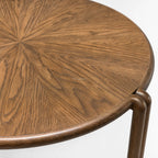 Orbit Coffee Table with a round veneer top in warm timber tones and sculptural birch legs.