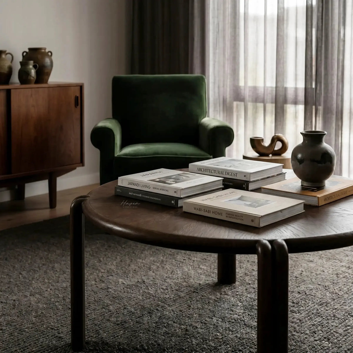 Orbit Coffee Table with round veneer top and sculptural birch legs in a cozy living room.