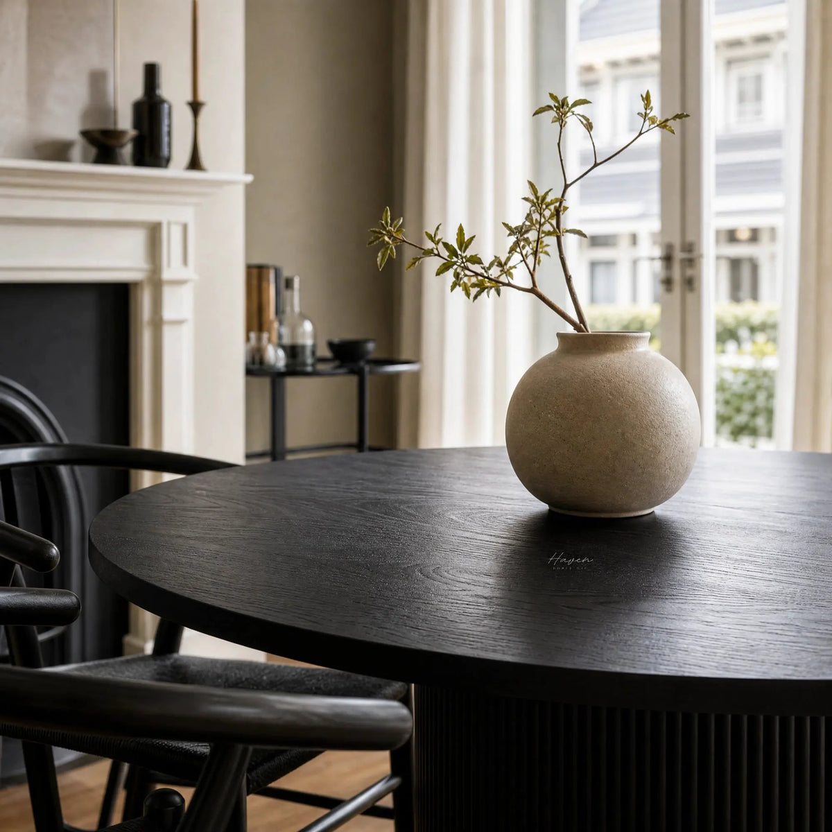 Sora Dining Table in Black with a round top and fluted pedestal base, fir wood and timber veneer.