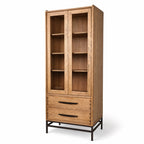 Halden Display Cupboard in solid oak with glass-front doors, open shelving, and a lower drawer on a black metal base.
