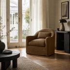 Nella slipcover armchair in warm Mocha linen features a softly curved silhouette and relaxed removable cover in a sunlit living room.