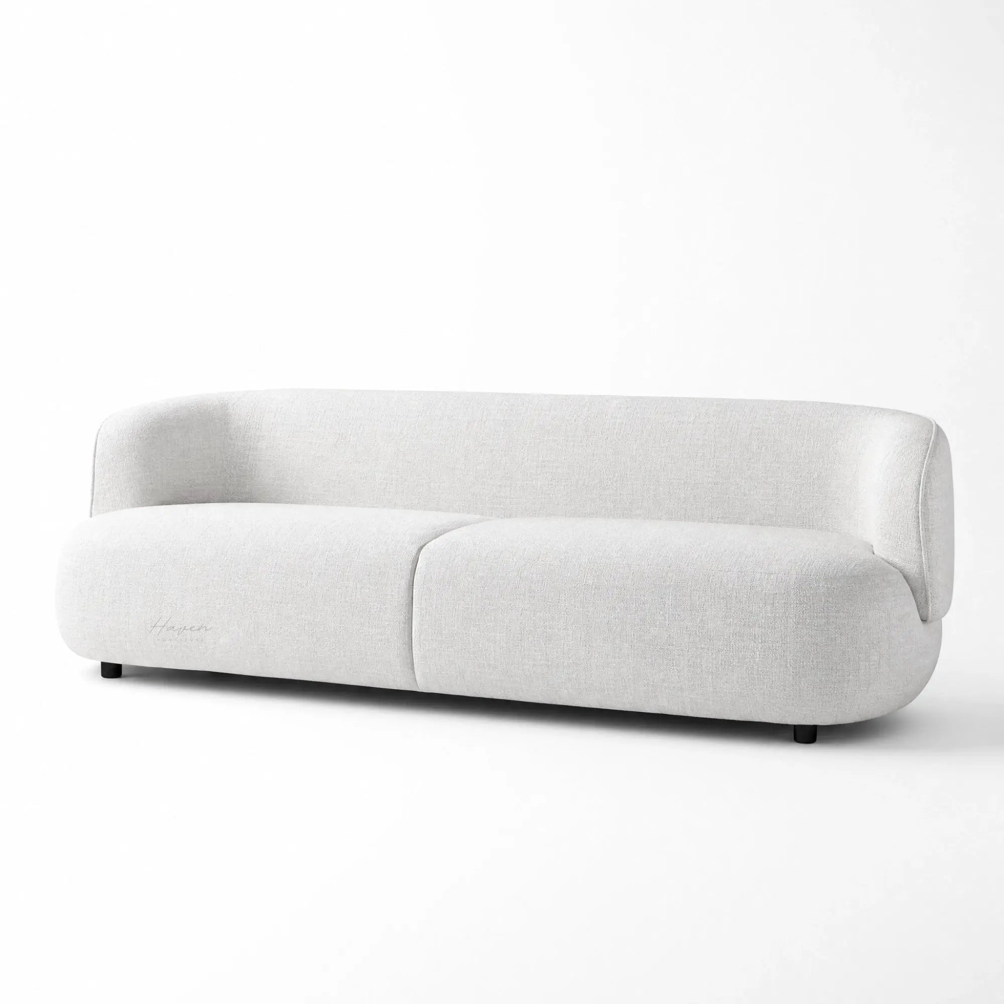 Low profile sofa with continuous curved back and pale textured upholstery bringing architectural calm to the room.