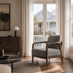 Kiso lounge chair with deep walnut frame, tapered legs, curved arms, and grey upholstery near bright window.