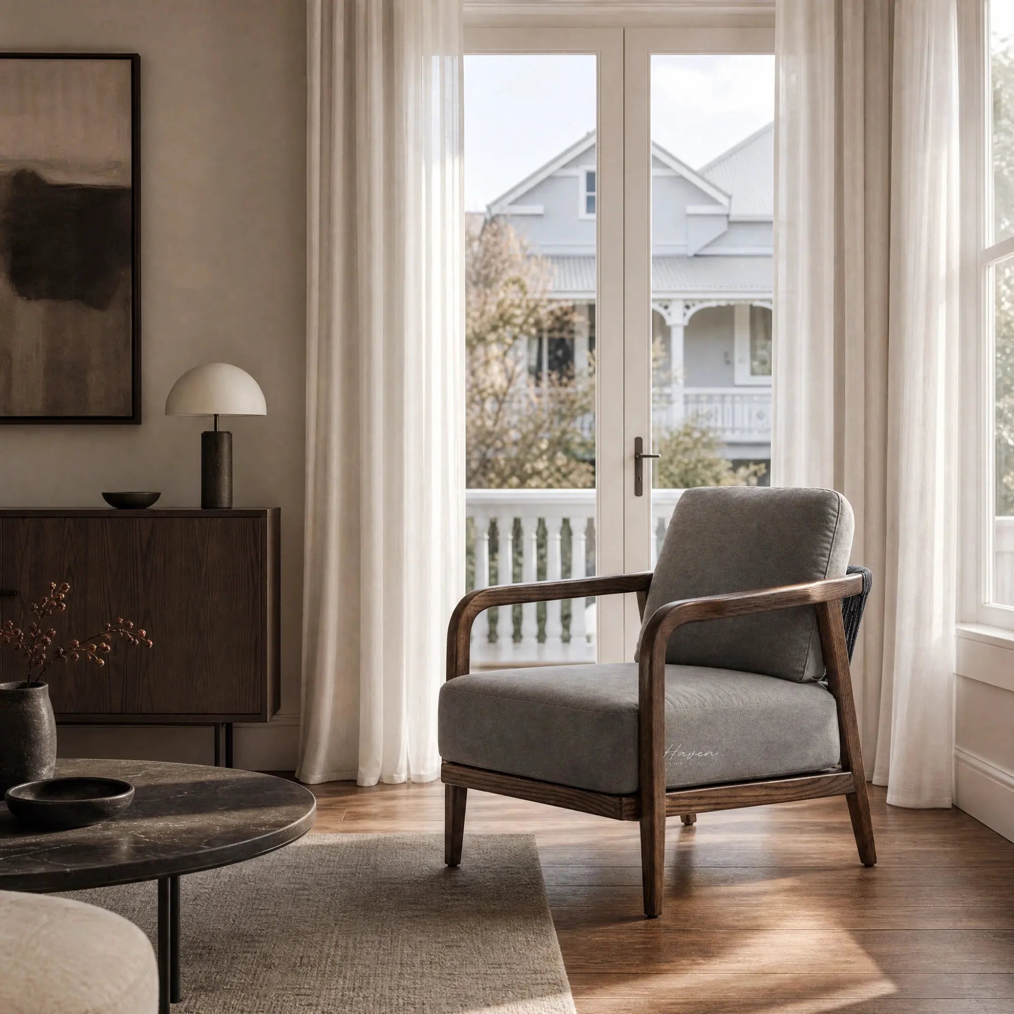 Kiso lounge chair with deep walnut frame, tapered legs, curved arms, and grey upholstery near bright window.