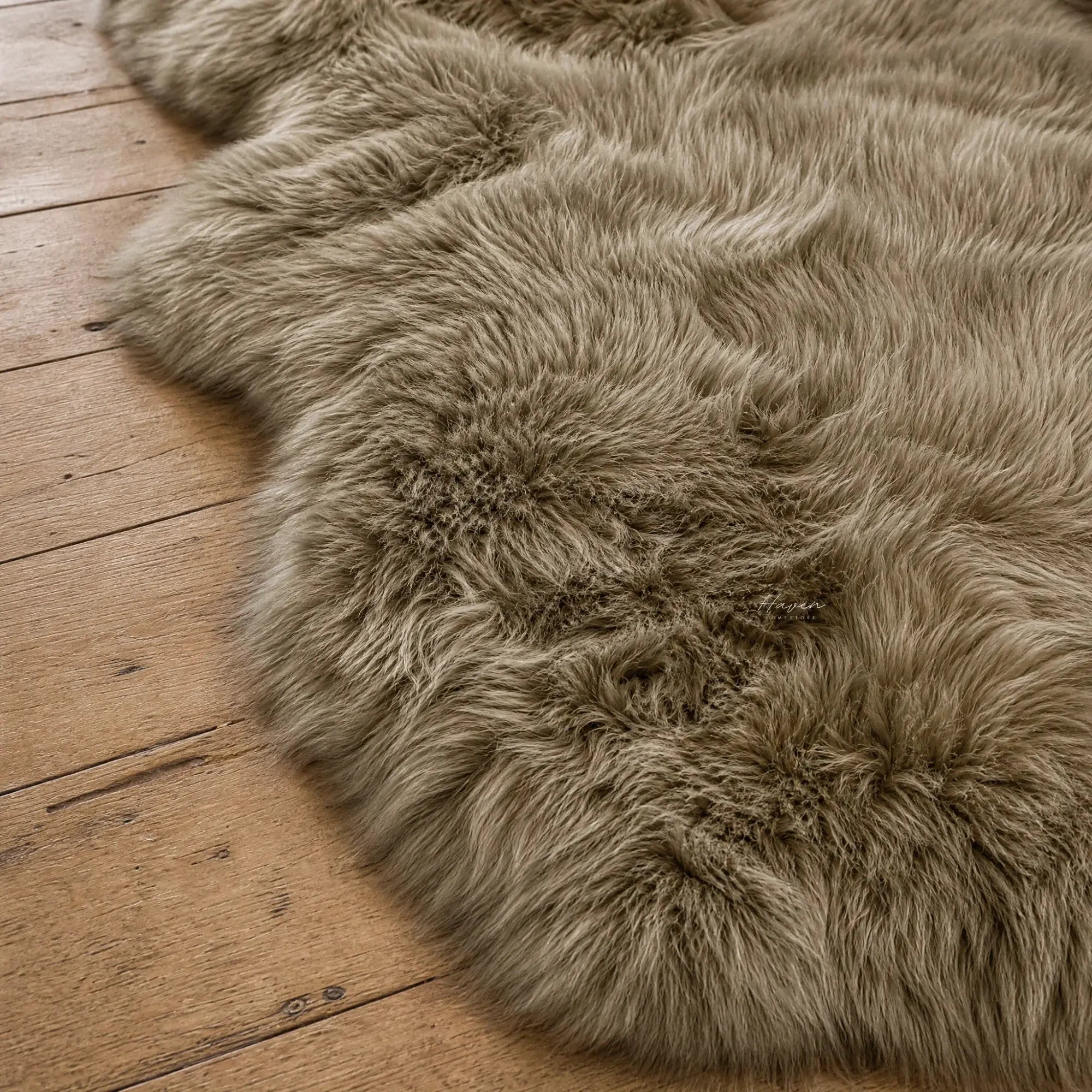 Taupe double sheepskin rug with long wool texture draped on wooden floor