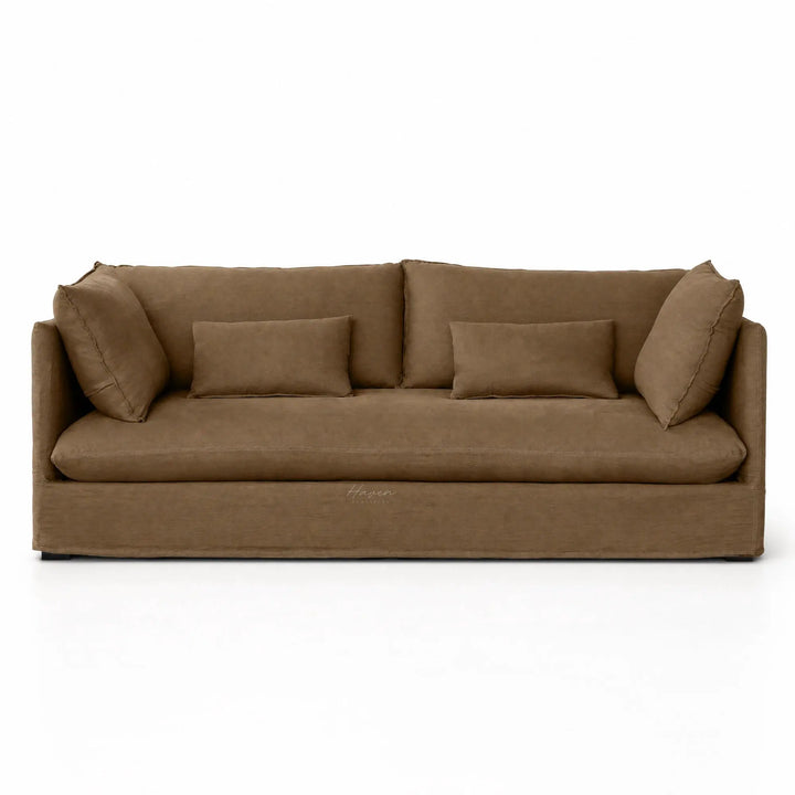 Low-set mocha linen slipcover sofa featuring relaxed tailored fabric, loose back cushions, and rectangular throw pillows.