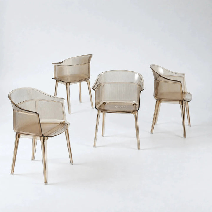 Set of four translucent amber polycarbonate chairs featuring a sculptural wraparound silhouette and fine vertical texture details.