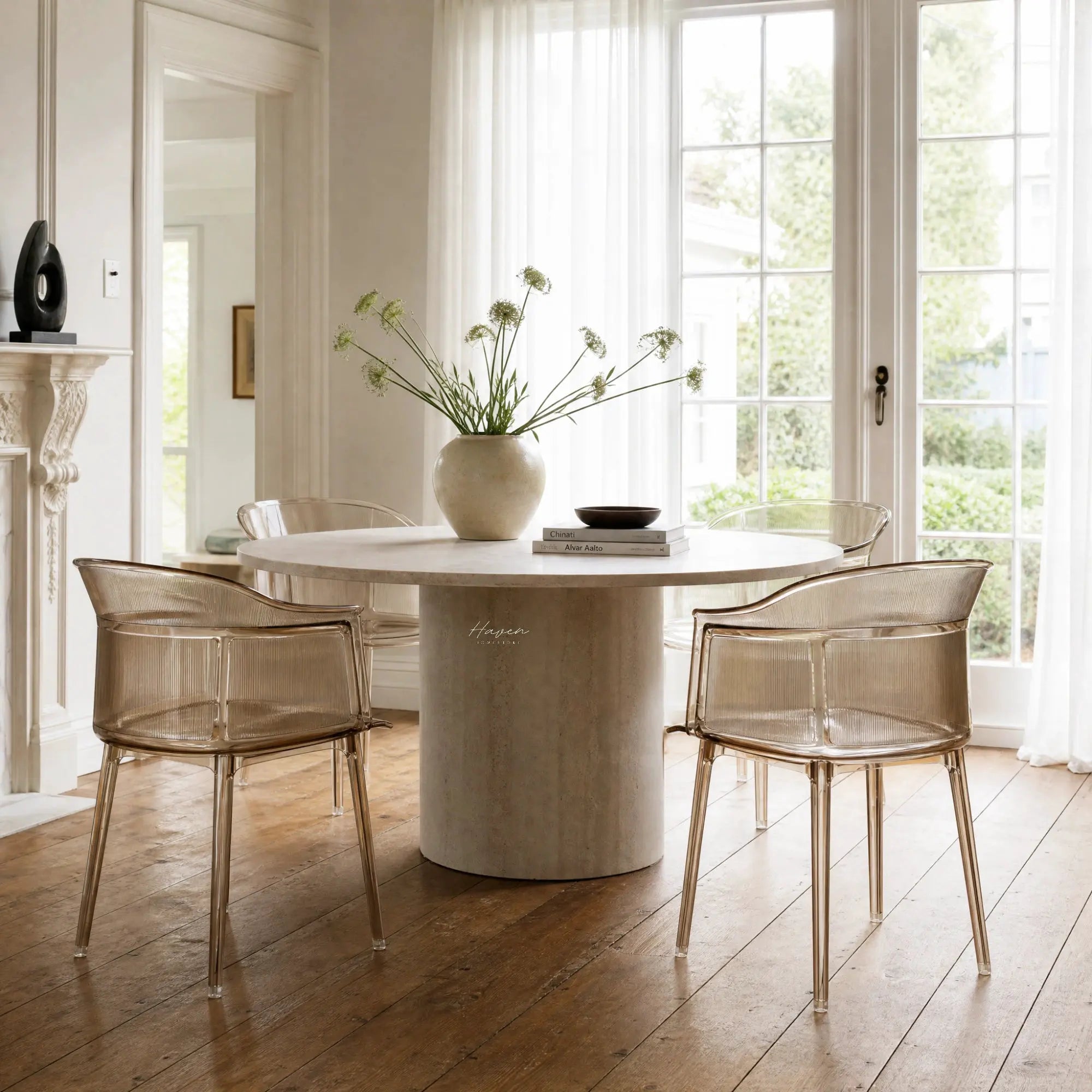 Set of four translucent amber polycarbonate chairs with vertical ribbing and wraparound silhouette around a round stone table.