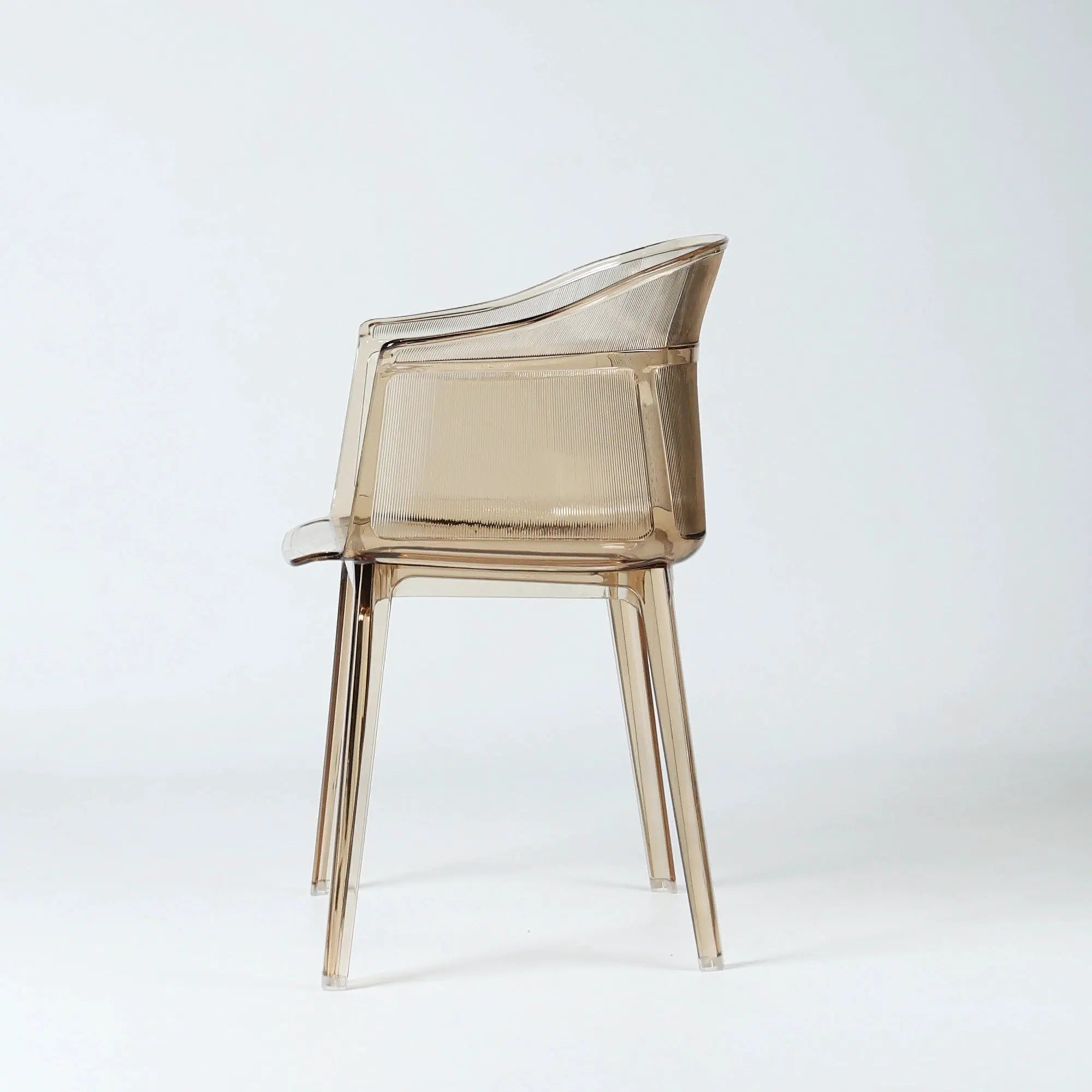 Translucent amber polycarbonate chair with sculptural wraparound silhouette and fine vertical texture detailing.