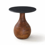 Sculptural side table with a black marble top and rounded mango wood pedestal base featuring an organic, tapering silhouette.