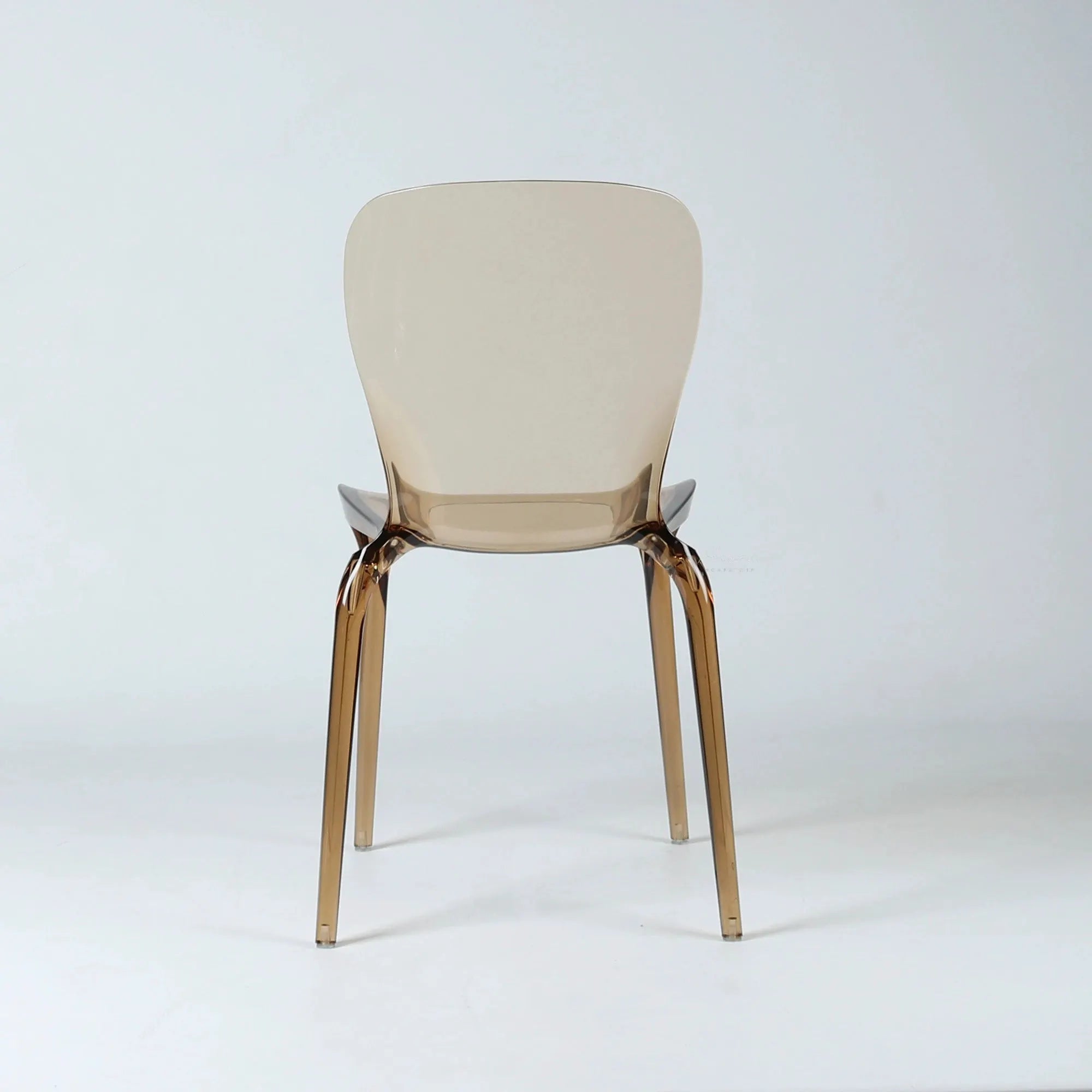 Amber transparent polycarbonate dining chair with softly curved back and slender legs.
