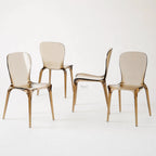 Set of four amber transparent polycarbonate dining chairs with curved backs and slender legs.