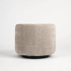 Oatmeal swivel chair with a rounded, sculptural profile, textured upholstery, and a discreet dark base.