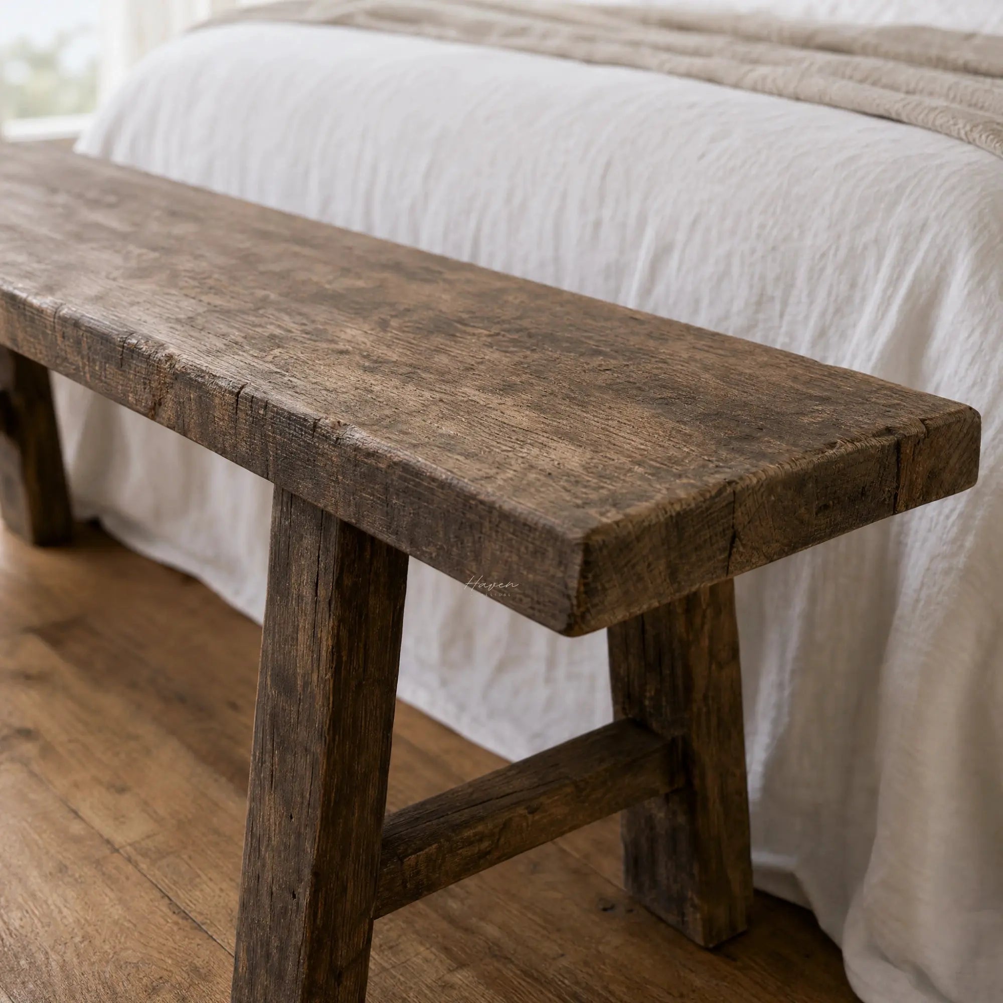 Reclaimed elm Estuary Bench 180 featuring a broad seat, substantial legs, and visible natural grain texture in a bedroom setting.