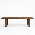 Reclaimed elm bench with broad seat, substantial legs, and visible grain knots against white background.