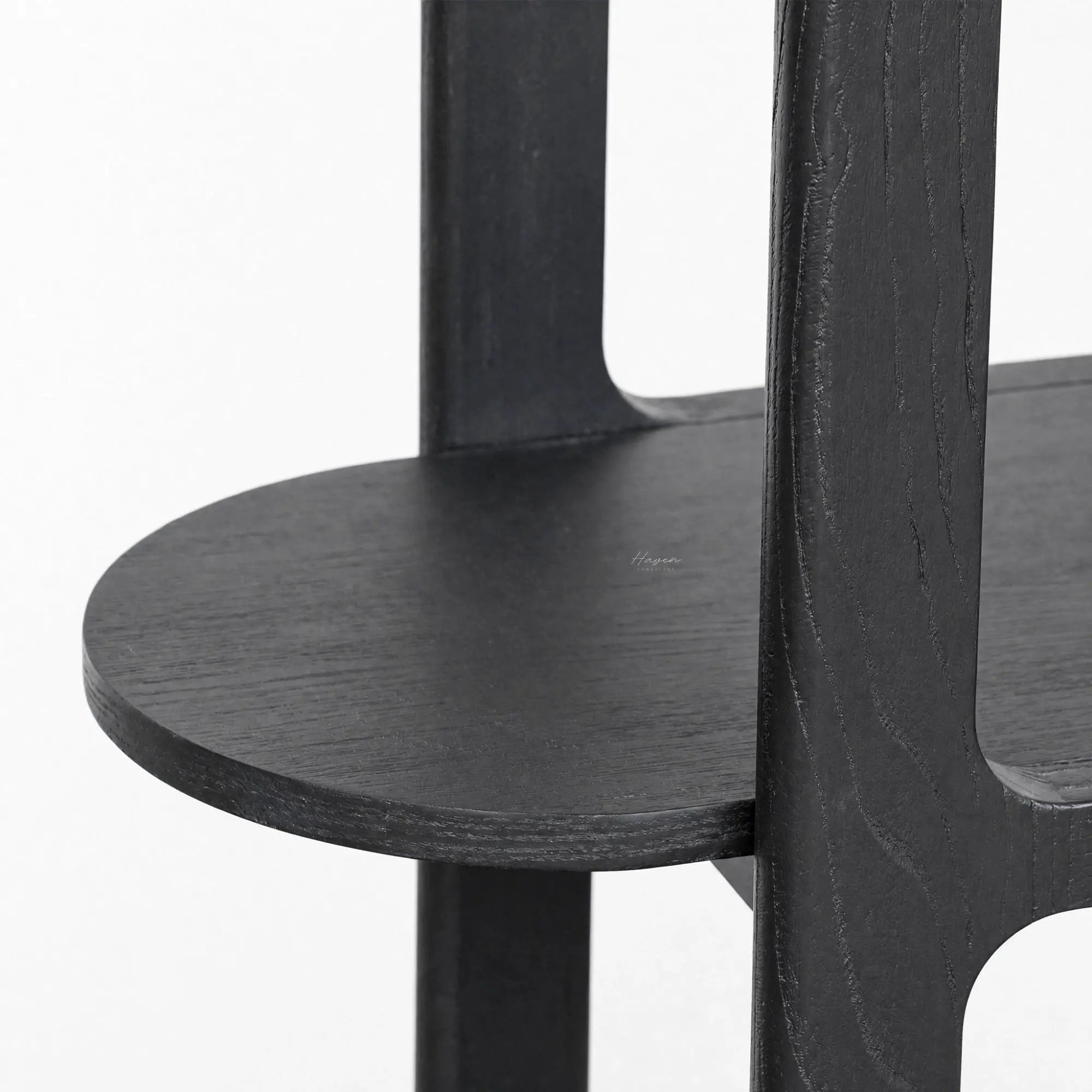 Close-up of black Hiro shelves featuring softly rounded corners, extending wood surfaces, and a tall open architectural framework.