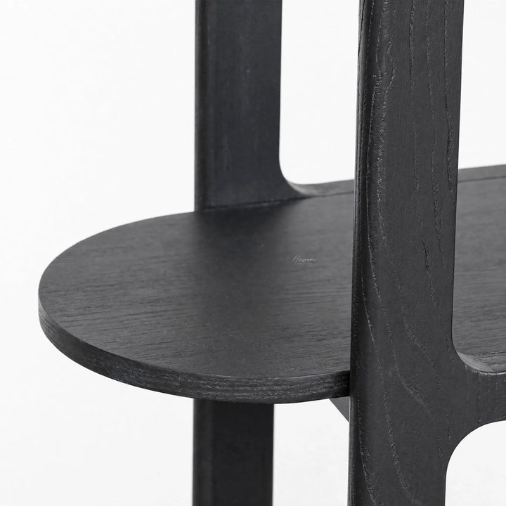 Close-up of black Hiro shelves featuring softly rounded corners, extending wood surfaces, and a tall open architectural framework.