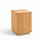 Minimalist oak side table featuring a warm timber grain, gently faceted surface, and precise dark corner joinery details.