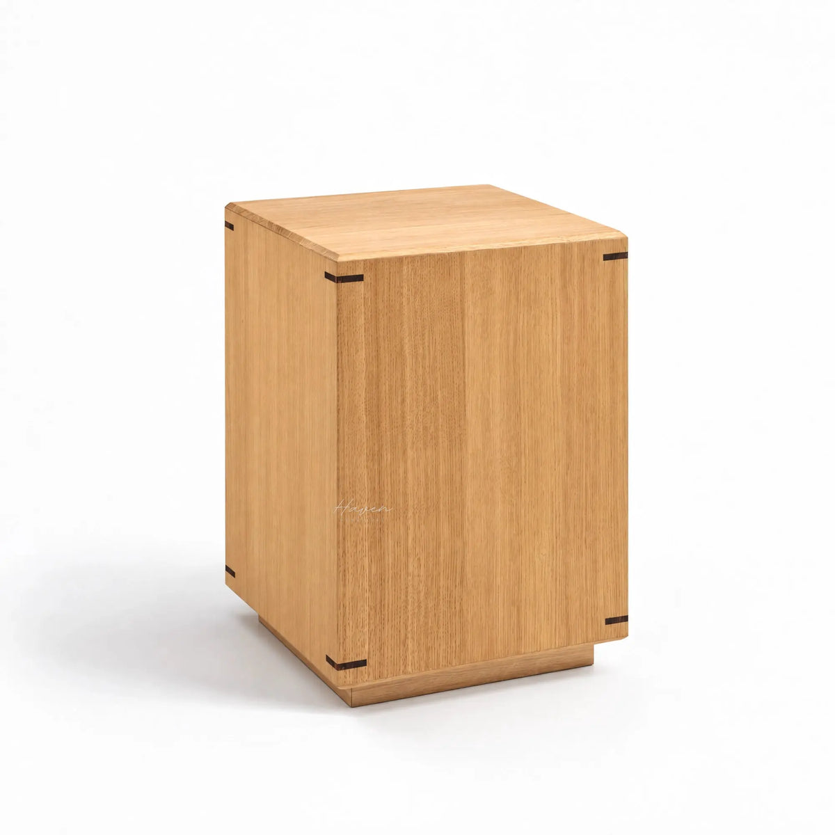 Minimalist oak side table featuring a warm timber grain, gently faceted surface, and precise dark corner joinery details.