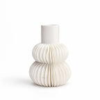 White bone china vase with sculptural tiered pleating, featuring two rounded volumes and a cylindrical neck.