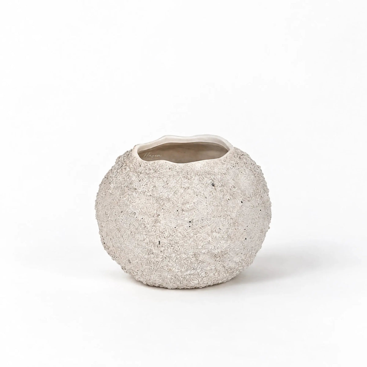 Rounded, low-set terracotta vase with a chalky off-white finish, textured grain, and irregular rim.