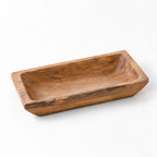 Solid teak tray with a low-set, rounded rectangular shape and recessed center, showcasing natural grain and knots.