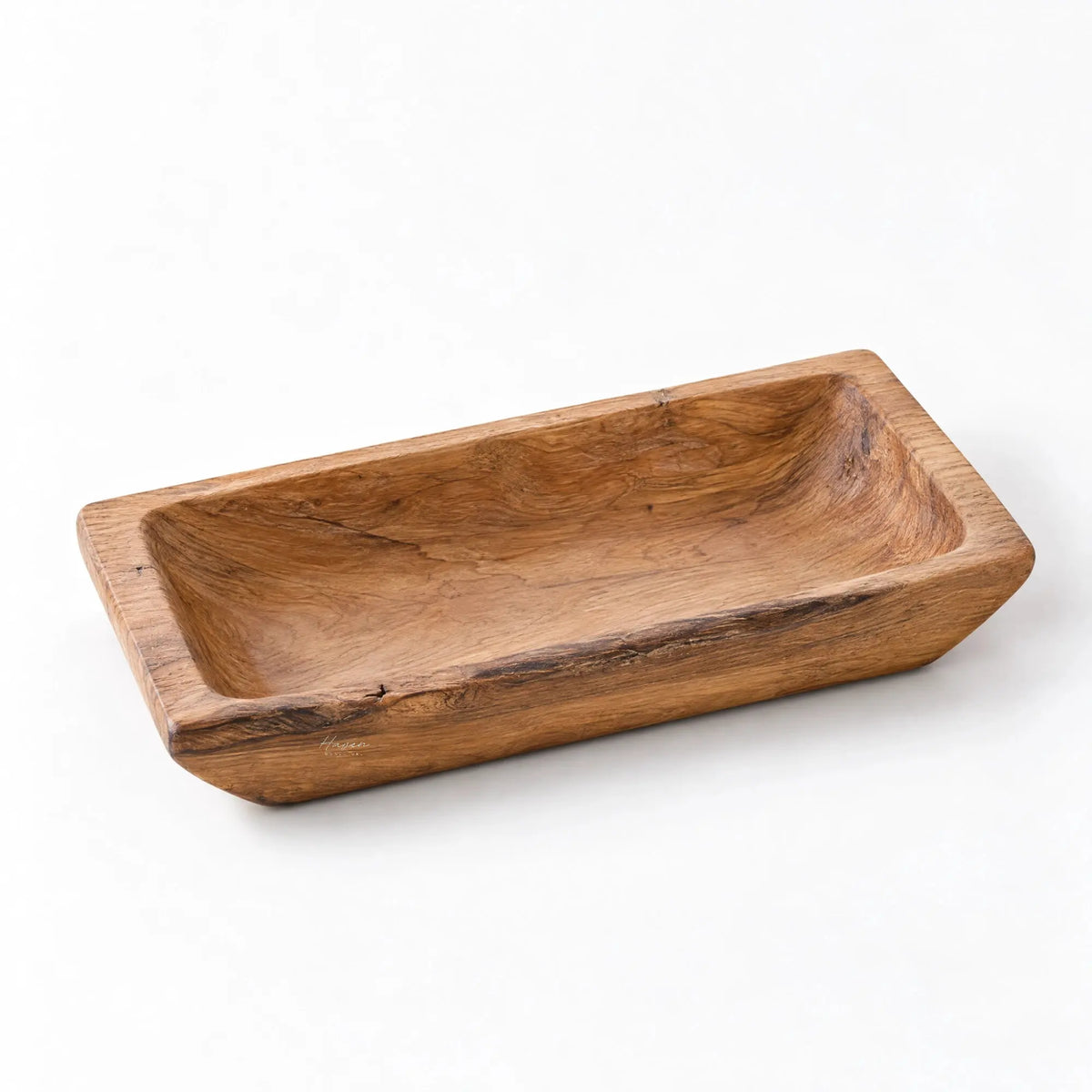 Solid teak tray with a low-set, rounded rectangular shape and recessed center, showcasing natural grain and knots.