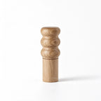 Natural oiled oak salt grinder with sculpted three-ring top and cylindrical base.