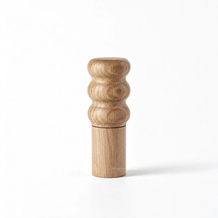 Natural oiled oak salt grinder with sculpted three-ring top and cylindrical base.