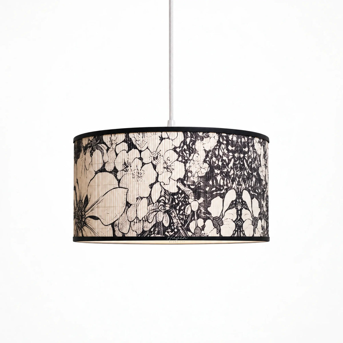 Drum pendant lightshade with bamboo texture and black botanical floral motif, framed by a slim black metal rim.