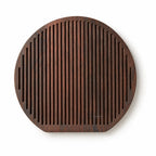 Round Yami cheese board with deep carbonised ash finish and rhythmic linear grooves for a sculptural serving presentation.