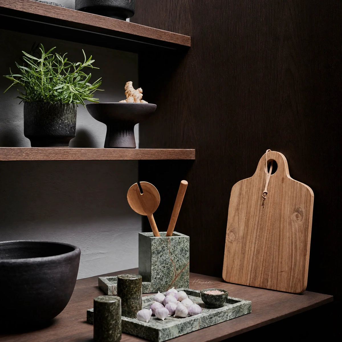 Seagreen marble tray with low architectural profile holding garlic and salt, showcasing natural veining and tonal variation on a wooden surface.