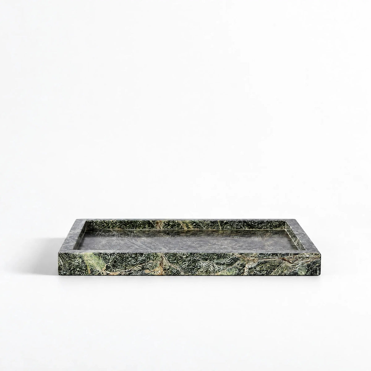 Rectangular green marble tray with deep veining and a low, architectural profile showcasing natural stone texture.