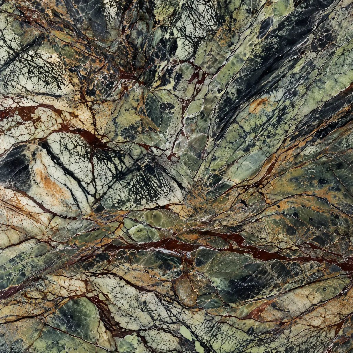 Green marble surface with dramatic black, white, and rust veining, showcasing the natural stone used for a sculptural tapas board.