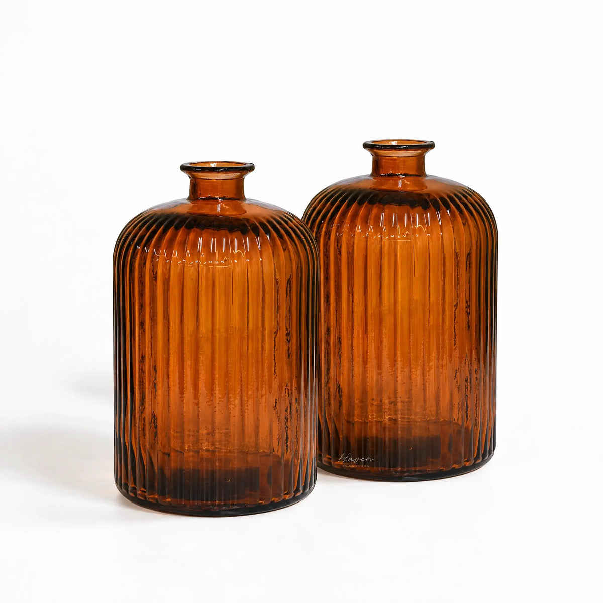 Set of two amber glass vases featuring soft rounded shoulders and fine vertical fluting made from recycled glass.
