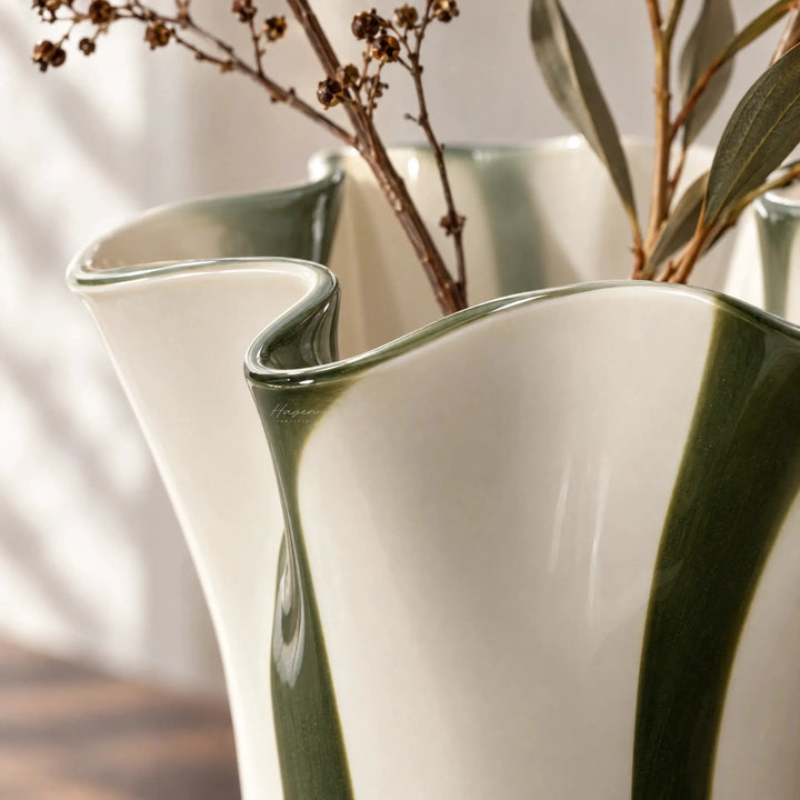 Mouthblown glass vase featuring a fluid, undulating rim and vertical stripes of hunter green against soft cream white.