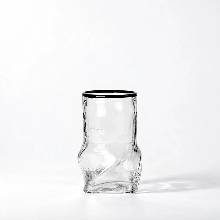 Clear glass vase with a defined black rim and a sculptural, distorted lower body featuring subtle refractions.