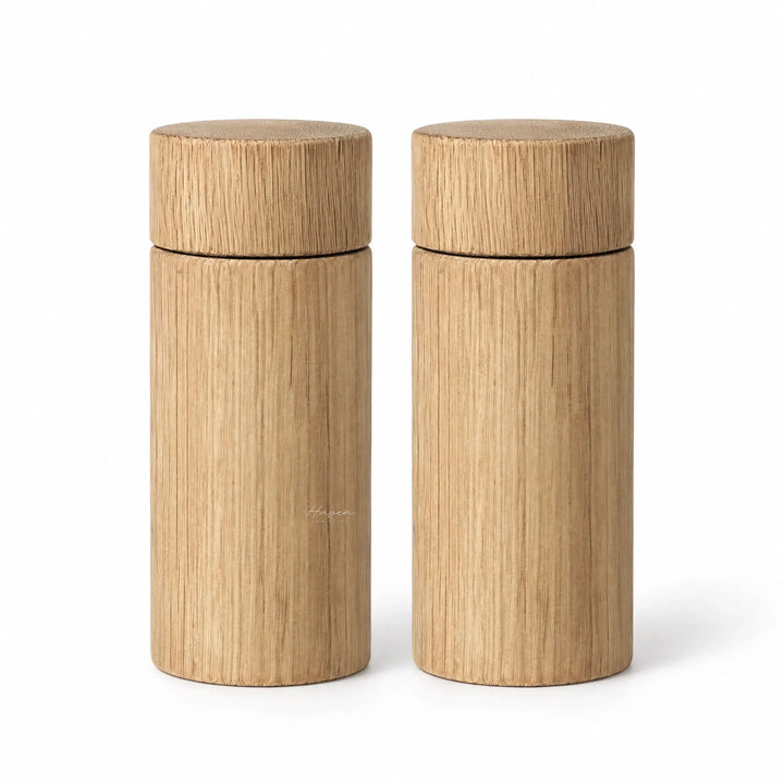 Set of two large cylindrical oak salt and pepper grinders featuring natural timber grain and a clean, minimalist profile.