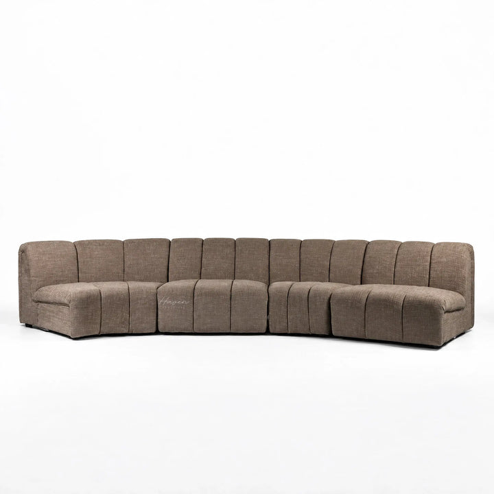 Long, low Arc Modular Sofa in Truffle featuring segmented textured polyester upholstery and a relaxed, curved architectural design.