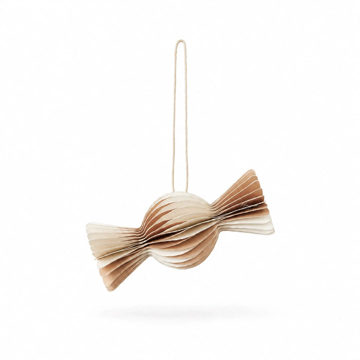 Layered paper candy ornament in off-white and natural brown, featuring ribbed folds and twisted ends hanging from a string.