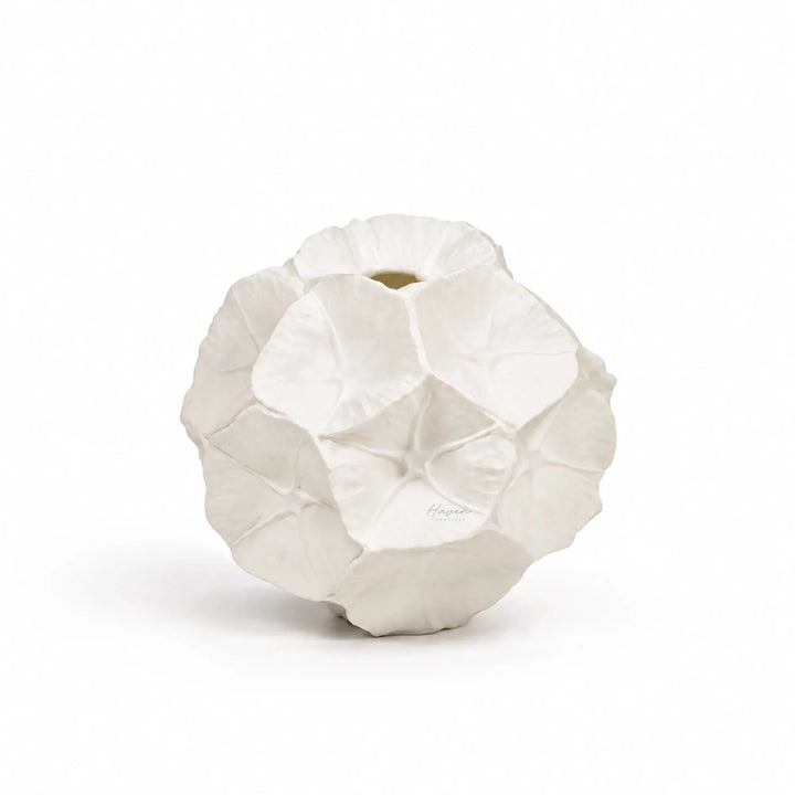White bone china star studded seed pod vase with rounded organic form and overlapping petal-like impressions.