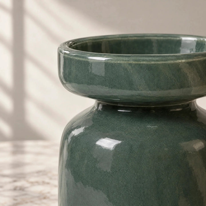 Dark green mouthblown glass vase with a softly rounded silhouette and gently flared mouth, showcasing muted translucency.