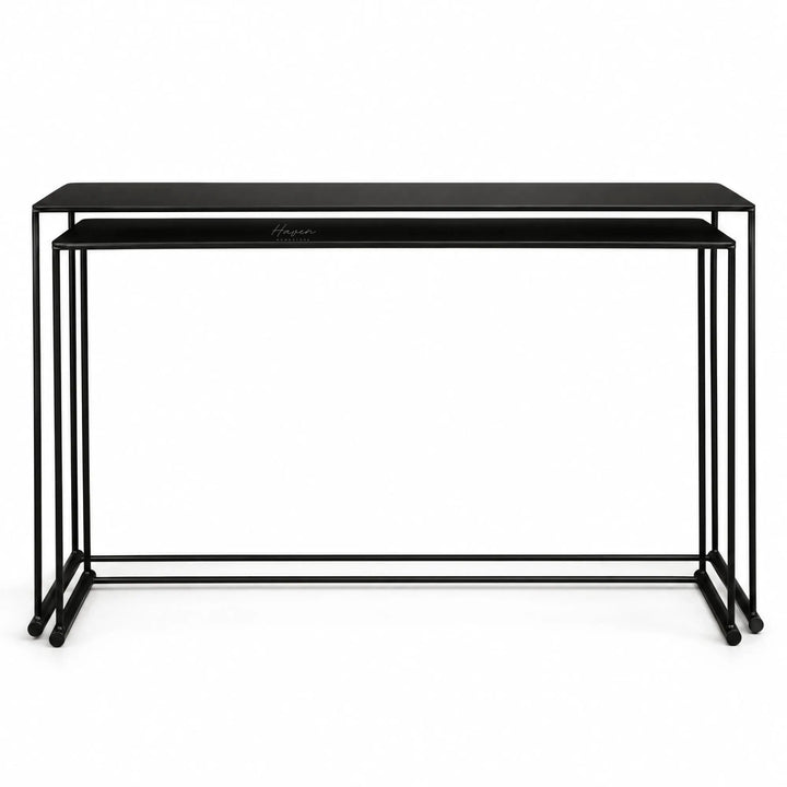 Black nesting console set with fine metal lines and elongated proportions, creating a layered architectural composition.