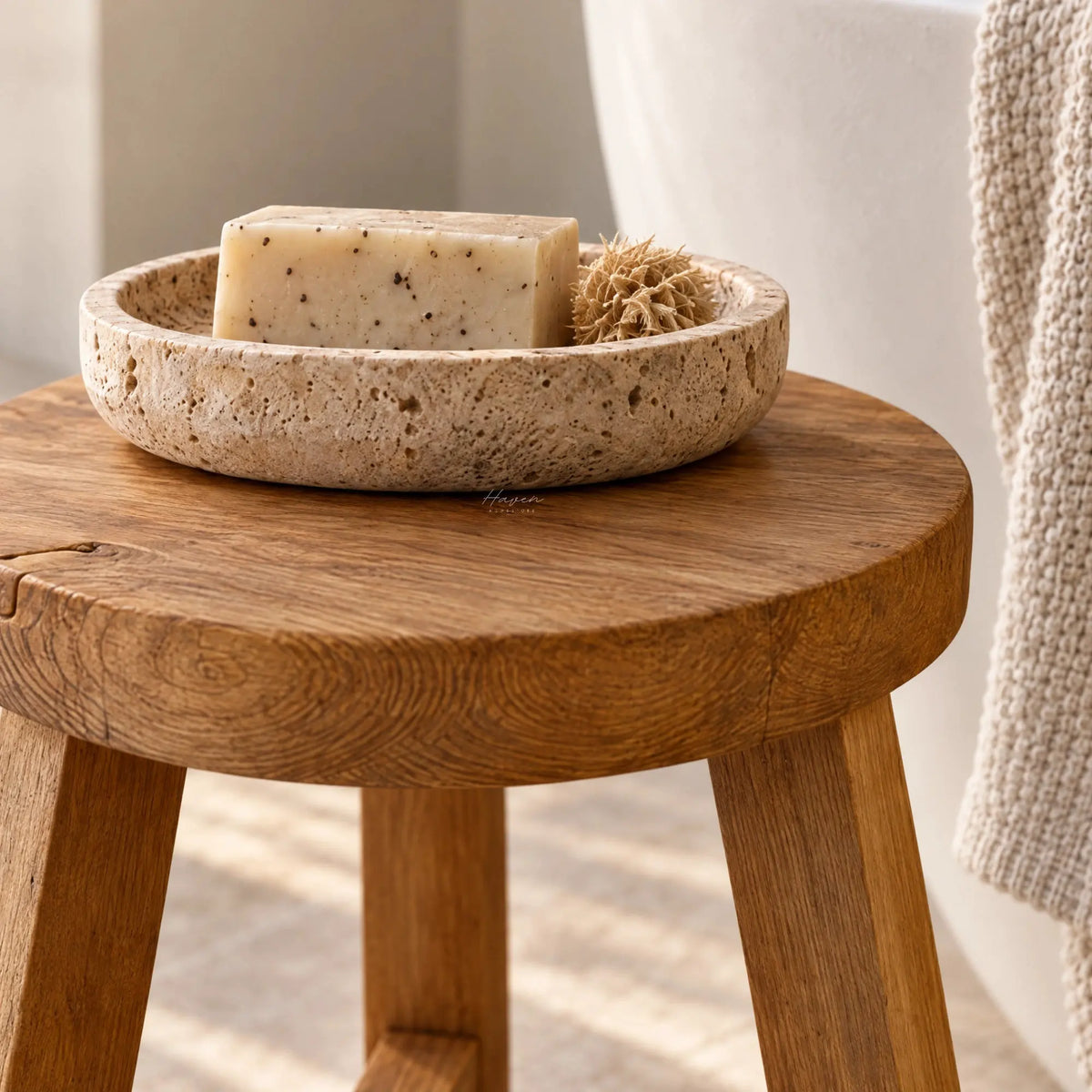 Reclaimed elm stool with visible grain and knots supporting a stone soap dish in a bathroom setting.